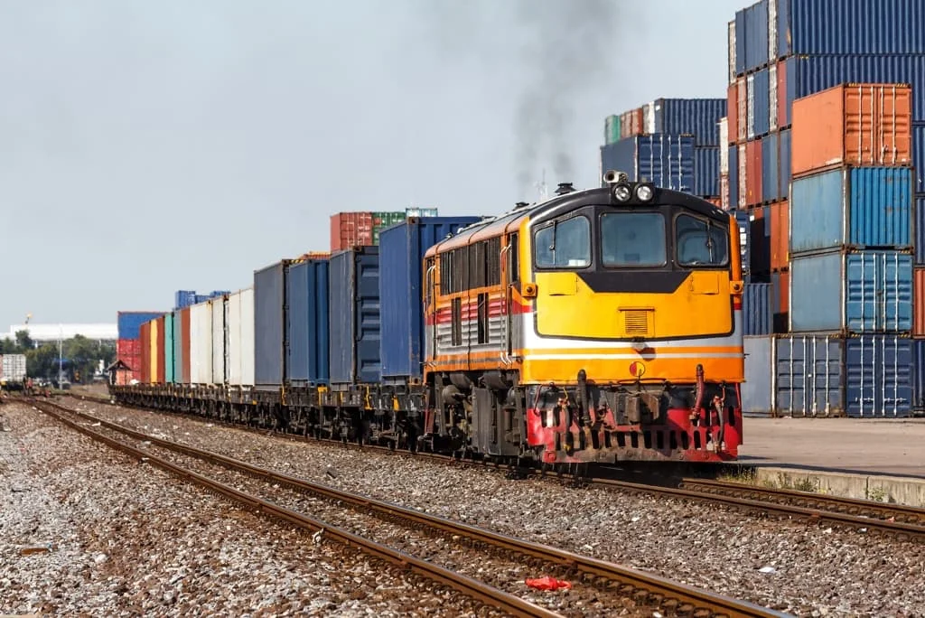 Freight train transporting shipping containers through an international cargo terminal