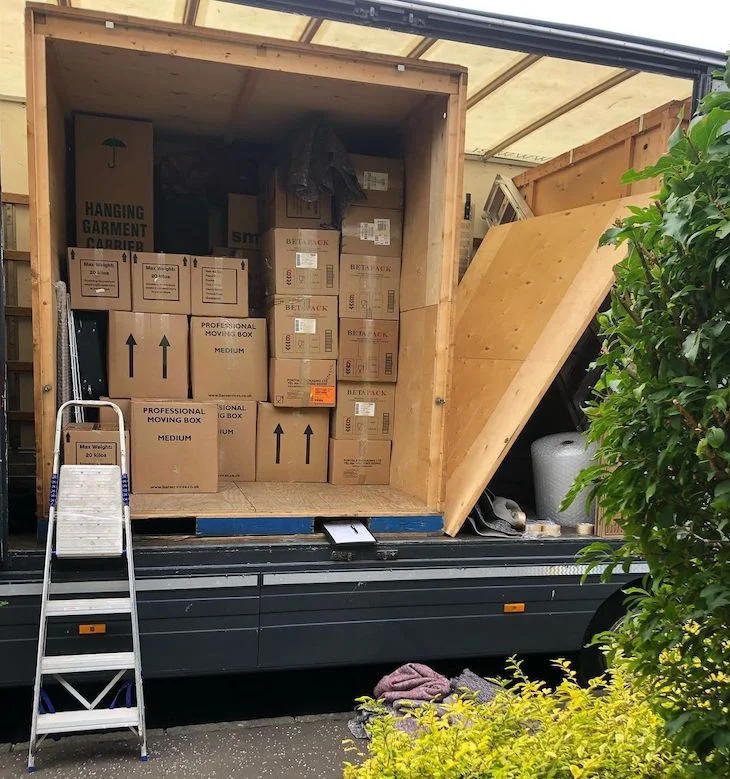 Storage container loaded on a removals vehicle with packed moving boxes